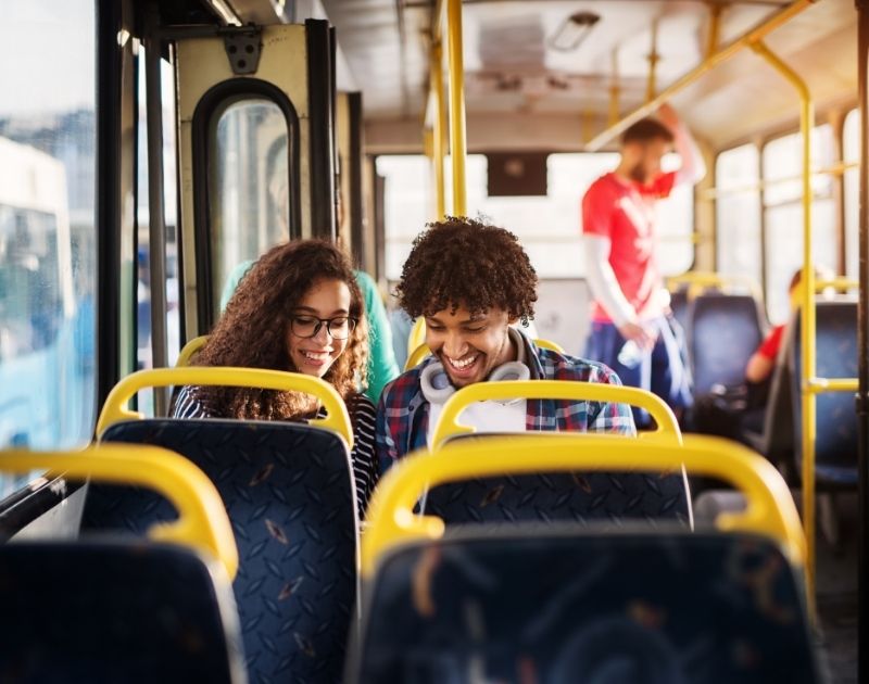 Transportation Image- Two college students sitting in a public bus.
