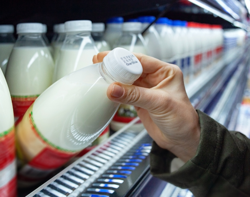 woman checking expiration date on milk